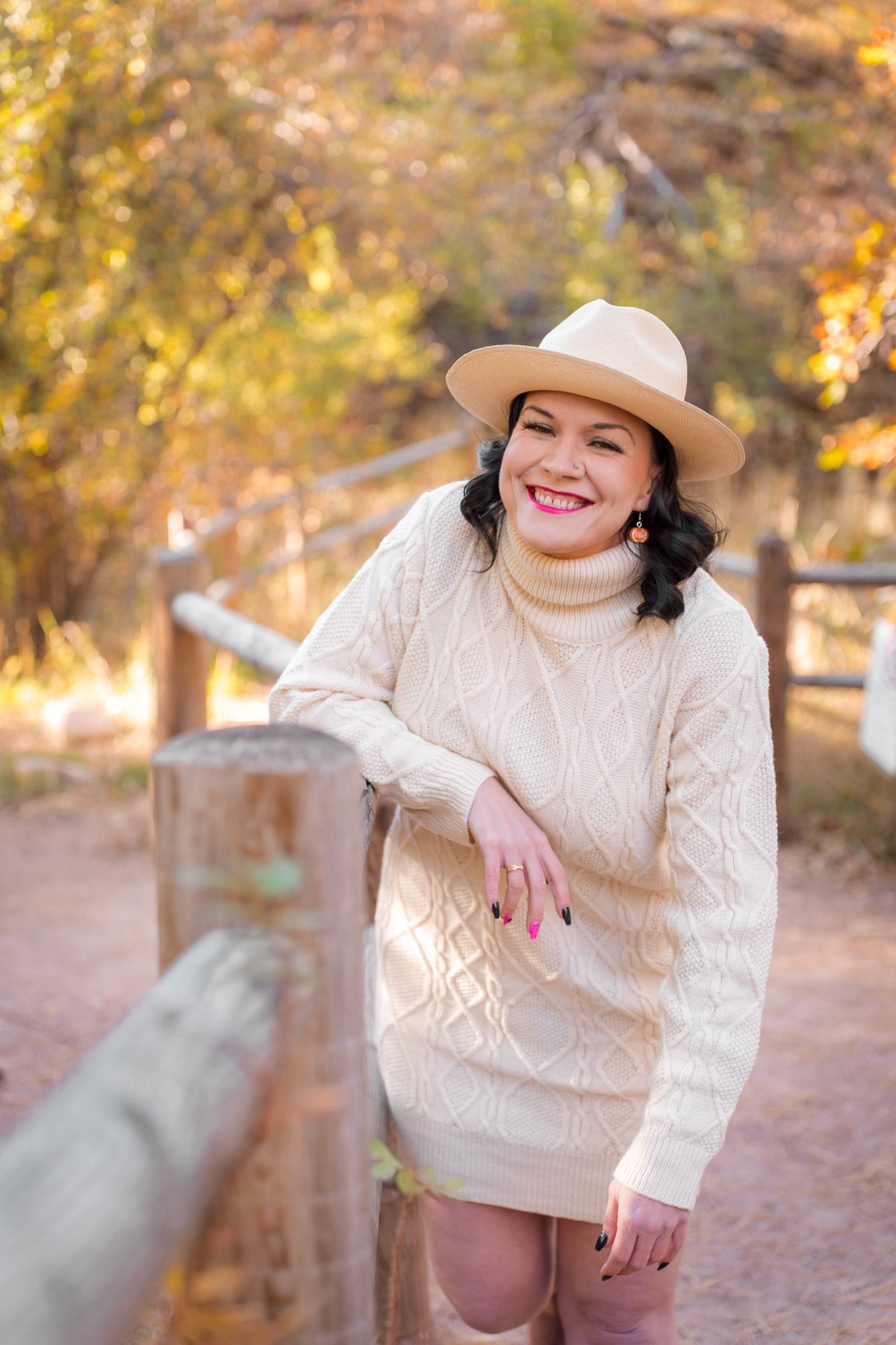 woman in white dress outside bending over laughing